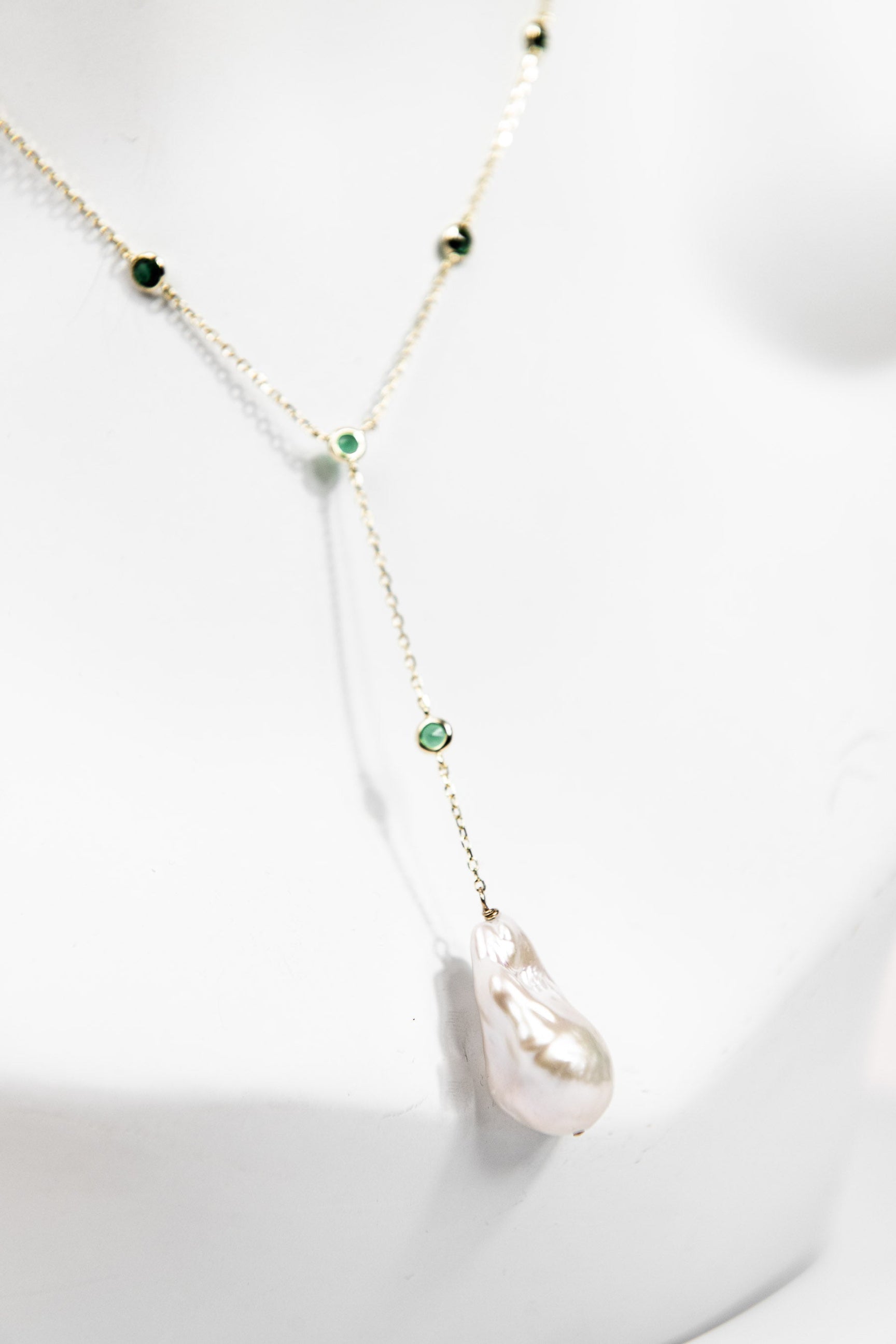 Baroque pearl lariat necklace with emerald crystal detail and gold chain