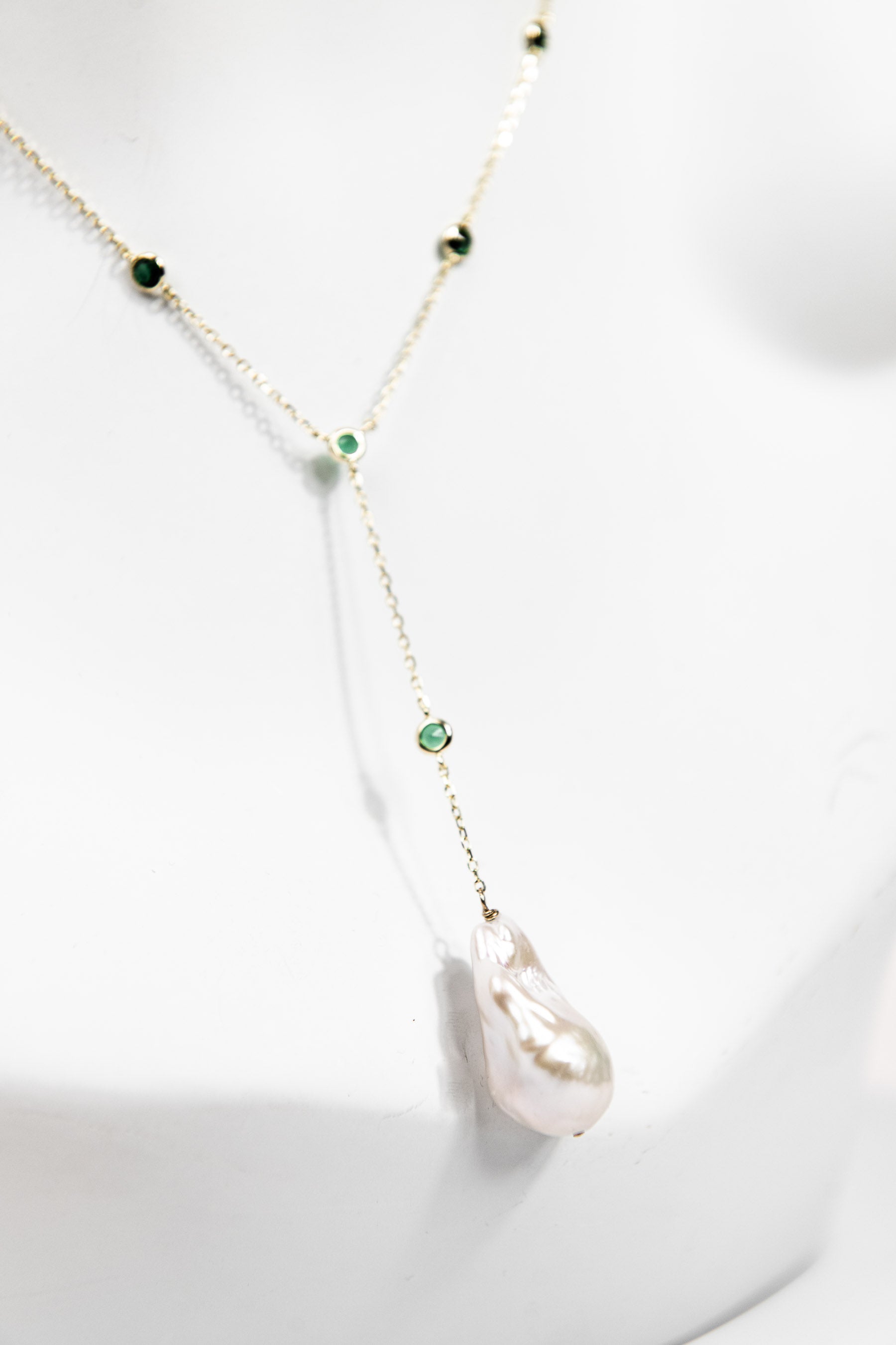 Baroque pearl lariat necklace with emerald crystal detail and gold chain